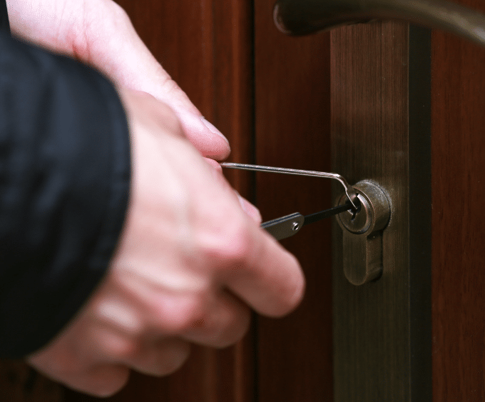 locksmith using lock pick tools to unlock a door